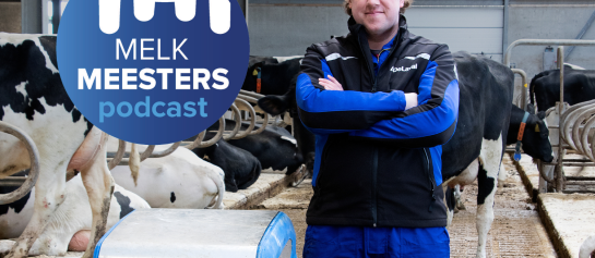 Maarten Burgmans, staand in de stal met koeien met de DeLaval mestrobot. Het logo van de podcast MelkMeesters is afgebeeld