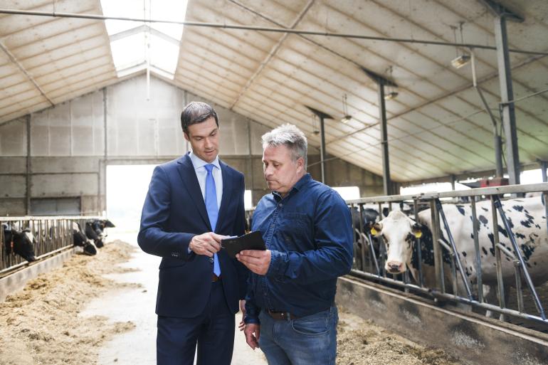 Een adviseur in gesprek met een melkveehouder