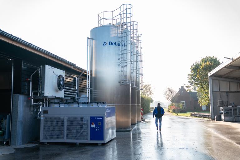 Persoon naast 3x DeLaval silotank DX3S en een Compact Water Chiller (CWC) van DeLaval
