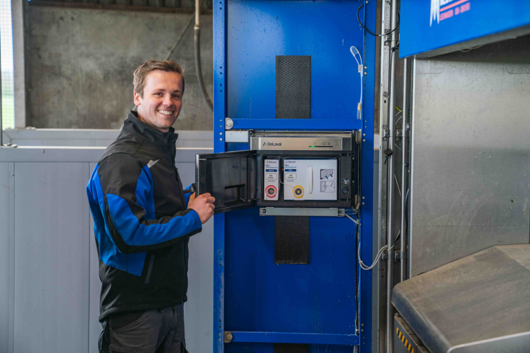 Melkveehouder naast de DeLaval BioSensors Milk Cell Analysis (MCA) in de VMS V300 melkrobot
