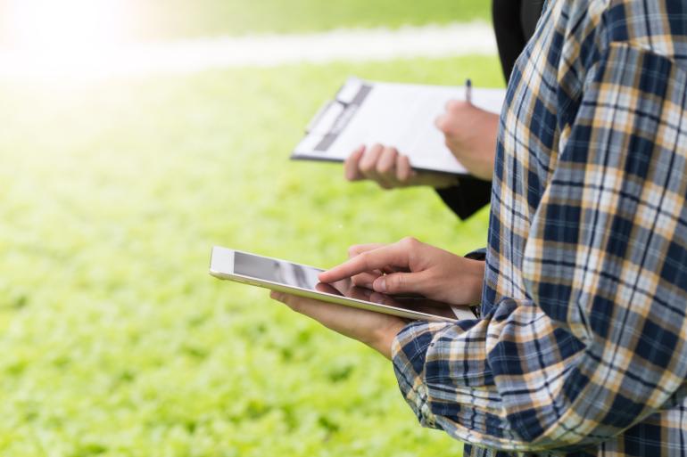 inspecterende boeren met klembord en tablet