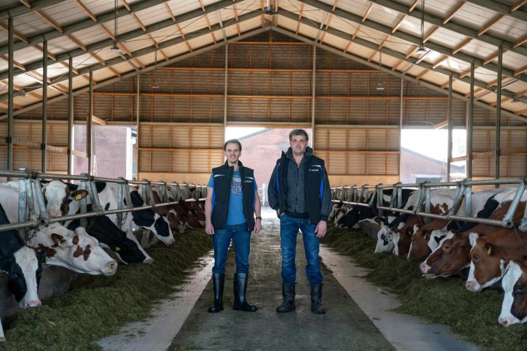 Melkveehouders Johan en Willem Loonen op de voergang bij Boerderij de Boterpot met DeLaval VMS Batch Milking