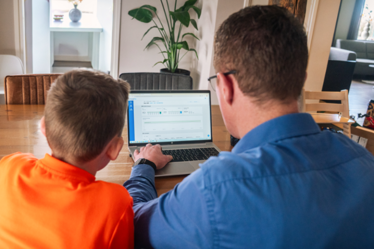 Melkveehouder Martin Brandsma met zoon achter de laptop met data vanuit Milk Solids Analysis in DeLaval Plus