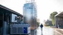 Persoon naast 3x DeLaval silotank DX3S en een Compact Water Chiller (CWC) van DeLaval