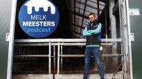 Melkveehouder Kasper van Beek voor de unieke ophaalbrug waar zijn koeien overheen lopen in zijn melkveestal. Samen met het logo van de Podcast Melkmeesters die gemaakt wordt door Veeteelt en DeLaval